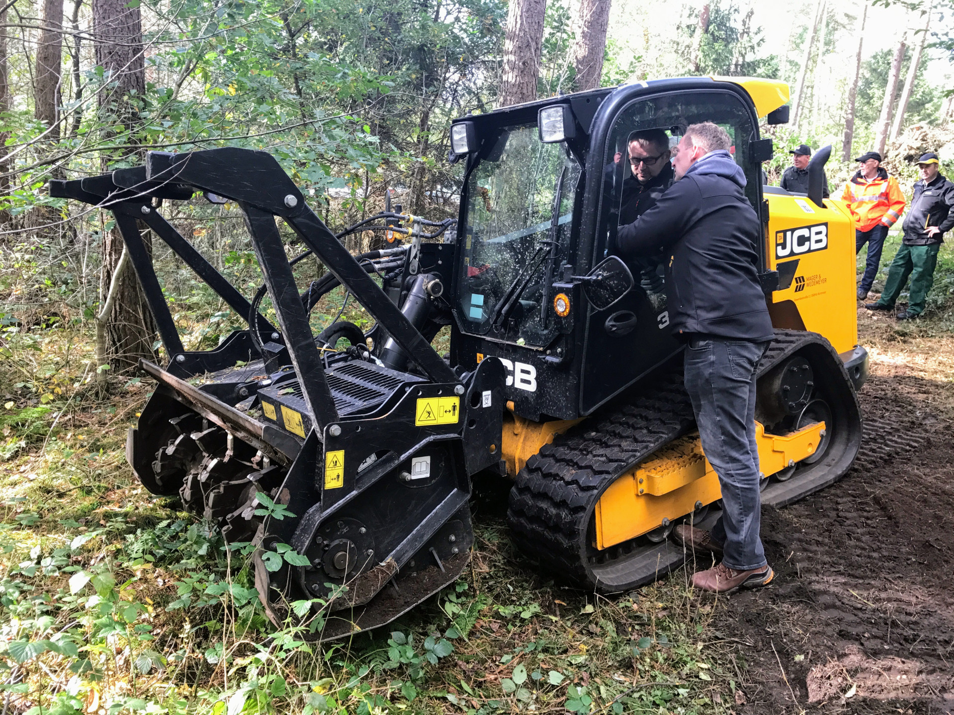 Lernen durch Begreifen: mit einem modernen Kompaktraupenlader (hier das Modell JCB 320 T) ist das Mulchen direkt zwischen den Bäumen kein Problem mehr.